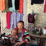 Chị Phạm Ngọc Yến sửa quần áo trong cửa hàng của mình.