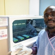 A lab technician stands in front of a HIV testing machine in Copperbelt Province.