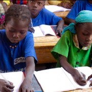 Young girls study their lessons in school. Only 44% of primary school girls will reach sixth grade.