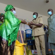 Ms. Elise Sophie Sagna, USAID/Saabuñinmaa coordinator, symbolically handing a bottle of vegetable oil to the Sub-Prefect of Niaguis as the Mayor of Adeane, Ibrahima Diedhiou, looks on