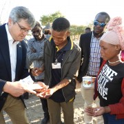 USAID Country Representative, Dr. Randy Kolstad, and community health worker Stephanus Mandjoro are counting the pills for 17 year-old drug-resistant TB patient Nqeni N/Hoakxa at the Duine Pos San community on the outskirts of Tsumkwe