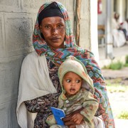 Image of Ethiopia mother and child with community health insurance card.