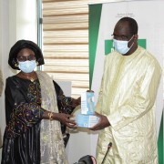 The Deputy Director of the USAID Health Office, Ms. Ramatoulaye Dioume, presenting a sample of the products to the Minister of Health and Social Action, Mr. Abdoulaye Diouf Sarr, during the symbolic handover ceremony.