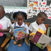 These kindergarten students from the Seventh Day Adventist Primary School in Grenada, seen reading while holding their 'reading buddies' have already benefitted from USAID's Early Learners program.
