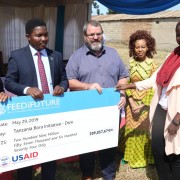 Abella Bateyunga (right) from the Tanzania Bora Initiative receives Advancing Youth grant for 209,057,674 TZ shillings. Abella is accompanied, from left to right, by Mbeya Regional Commissioner, J. Chalamila; PO-RALG Minister, Selemani Jafo; USAID Mission Director, Andrew Karas; and USAID Private Sector and Youth Project Management Specialist Joyce Mndambi.