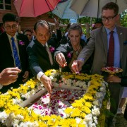 USAID Program Office Director Steven Majors, second from right, lays flowers on the cornerstone for a new hospital in Sangkhlaburi.