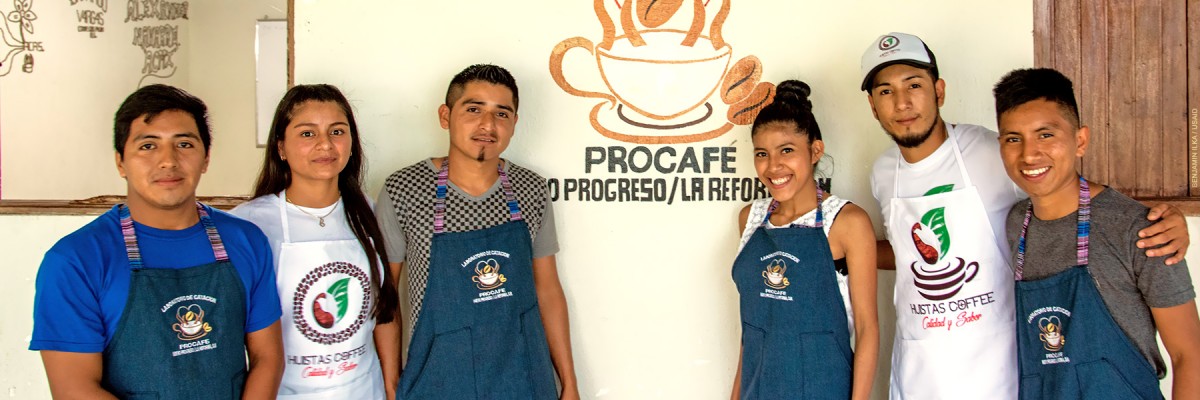 Six proud young members of a coffee collective pose in front of their cupping room.