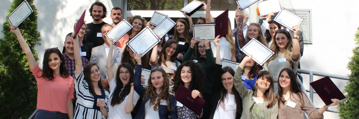 A group of young people cheer and hold up certificates