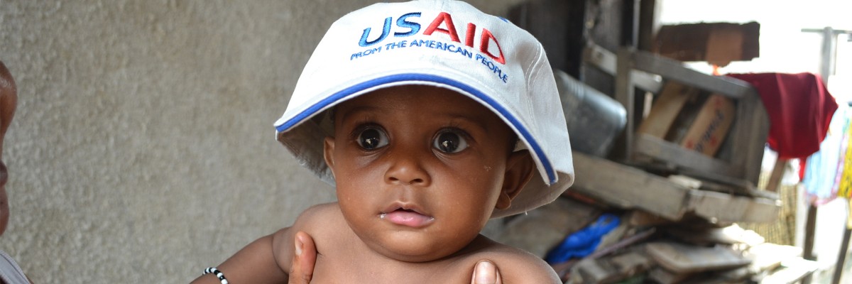Toddler in Abidjan wearing a USAID cap