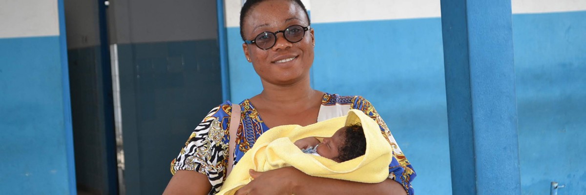 Smiling woman holds her newborn