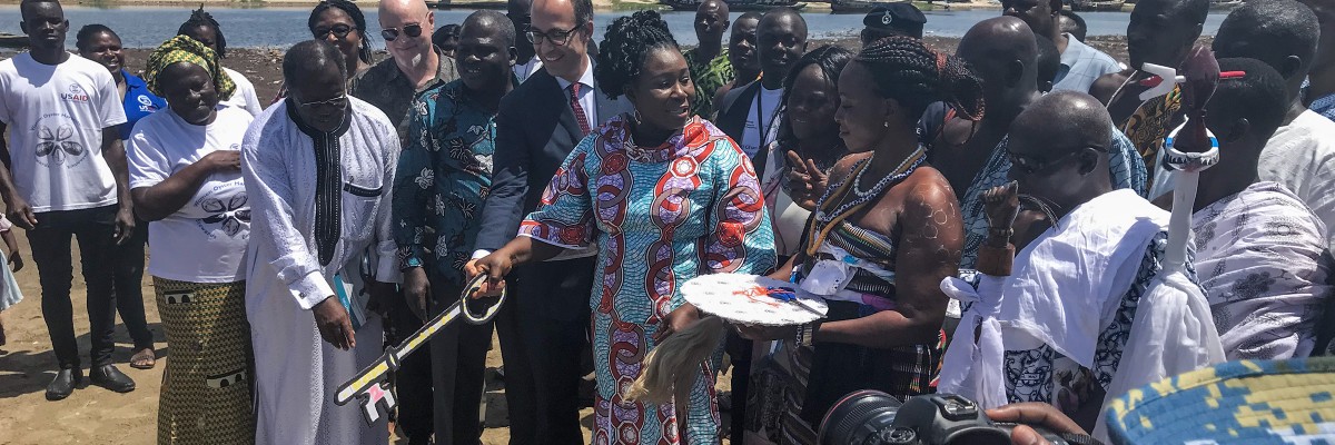 Minister of Fisheries Hon. Elizabeth Naa Afoley Quaye being assisted by Acting Economic Growth Director, USAID/Ghana and Nii Ampofo Palm to symbolically open the oyster harvesting season.