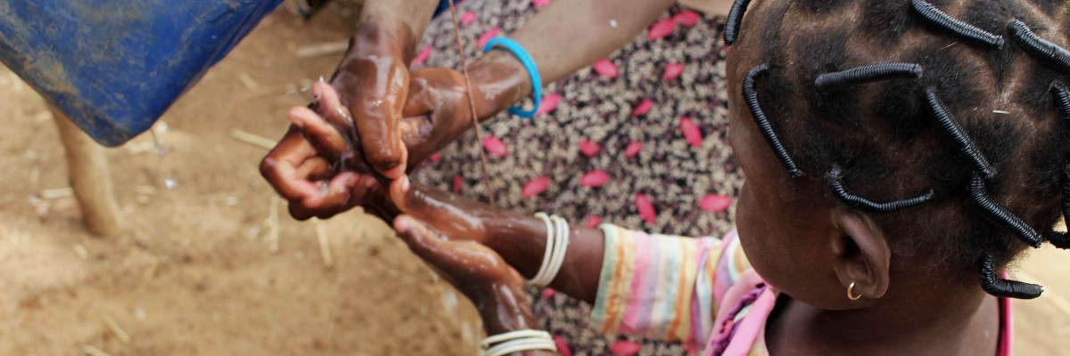 A young Burkinabe girl washing her hands